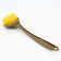 A dispenser for liquid soap with a sponge and a brush for dishes, white, 16 x 12 x 4 cm.