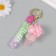 A keychain plastic with a carbine, a strap "Lollipop with a bow" Water with a glitter of 4x4x6.5 cm