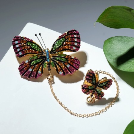 A brooch with an icon on the chain "Butterfly", colored in gold