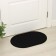The rug is a groomed moisture -drinking “scales”, 40 × 60 cm, black color