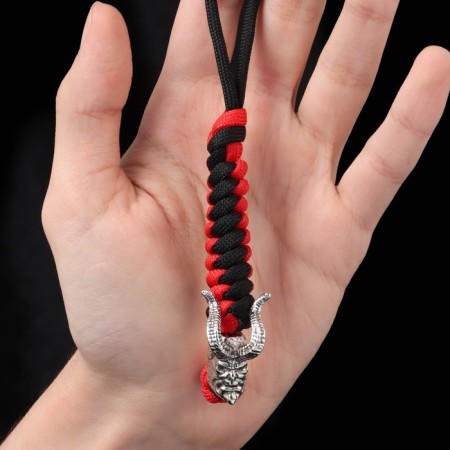 A keychain is a label for a Hellbo knife from a paracord, black and red