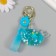 A plastic keychain with a carbine, a whale strap of water with sparkles 4x7x2.5 cm