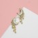Earrings with “crescent” rhinestones, the color is white in gold