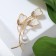 Brooch "Flowers" trio with bead, white color in gold