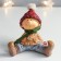 Polystone souvenir "Baby in a red hat and green scarf sits" 12.5x12x12.5 cm