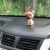 Dog on a car panel shocking his head, pug