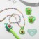 Set of children's "chosen" 5 items: 2 elastic bands, pendant, bracelet, pen, avocado, colored