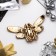 Brooch "Bee" with openwork wings, black and white color in gold