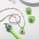 Set of children's "chosen" 5 items: 2 elastic bands, pendant, bracelet, pen, avocado, colored