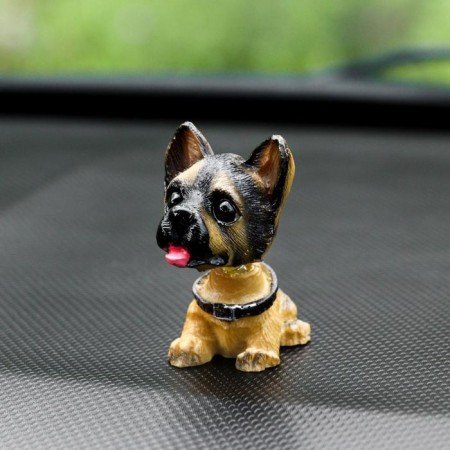 Dog on a car panel shocking his head, German shepherd