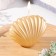 Figured varnished “shell” candle, 3.2x4.5 cm, gold