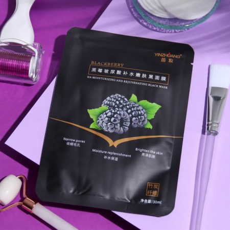 The mask is black fabric, moisturizing, for the face, with blackberry extract
