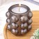 A candle in a candlelight made of gypsum with spherical faces, 10x10cm, gray-brown