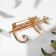 Brooch "cat" tropical on a branch, colored in gold