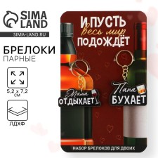 The paired key fobs “Dad Bujet/Mom Rests”, 5.2 x 7.2 cm.
