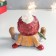 Polystone souvenir "Baby in a red hat and green scarf sits" 12.5x12x12.5 cm