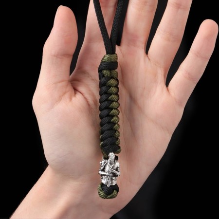 A keychain is a label for a knight knife from a paracord, black and green