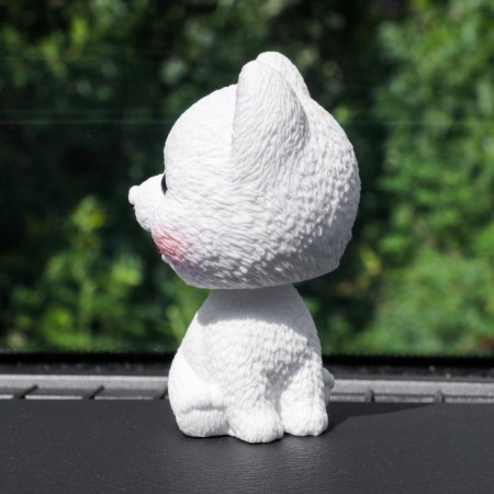 Dog on a car panel shocking his head, spitz-1