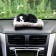 Toy on a car panel, dog on a pillow, black color