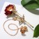 A brooch with an icon on the chain "flower" rose, the color is red-green in gold