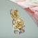 Broach "Bunny" with a bow, the color is white in matte gold