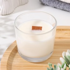 A candle made of soy wax in a glass with a wooden wick 