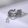 The ring "chains" intertwined, the color is white in silver, dimensionless
