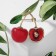 Brooch "Cherry" with a bone, the color is red-green in gold