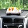 A toy on a car panel, a dog on a pillow, a white-red color