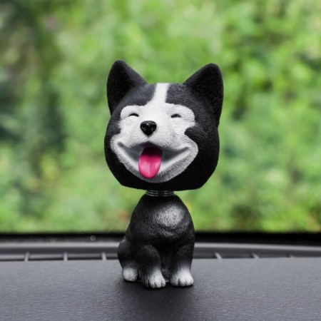 Dog on a car panel shocking his head, Husky, black