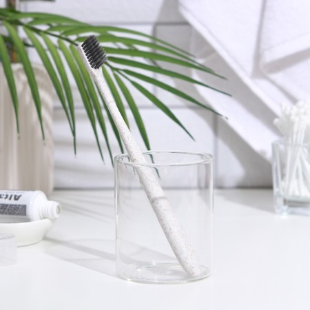 The toothbrush is soft, in the tube, white