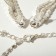 Set 2 objects: earrings, necklaces of “sparks” brushes, white color in silver, 30 cm