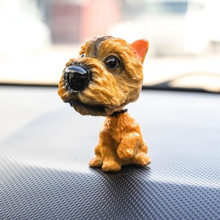 Dog on a car panel shocking his head, Irish Terrier