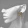 Earrings with rhinestones "flowers" bends, white color in gold