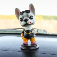 Dog on a car panel shocking his head, French bulldog