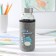 A glass bottle in a “dino” case, 300 ml, h = 17 cm, mix drawing