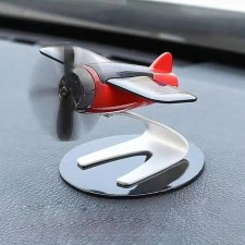 A toy on a car panel, a plane, a propeller spins from the sun, black