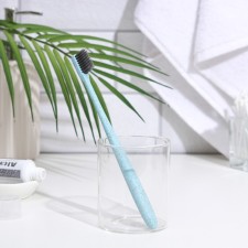 The toothbrush is soft, in the tube, turquoise