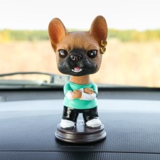 Dog on a car panel shocking his head, French bulldog