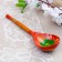 A spoon of wooden "rubella", a half -bacon, a red background