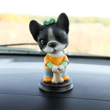 Dog on a car panel shocking his head, French bulldog