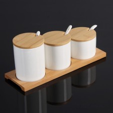 A set of ceramic cans for bulk products with spoons on a wooden stand of the Estet Dolyan, 3 banks: 200 ml, 250 ml, 350 ml, white color