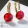 Earrings with Crystal rhinestones are bright, white-red color in gold