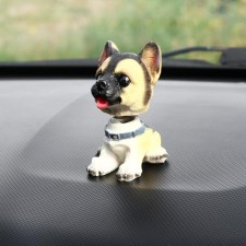 Dog on a car panel shocking his head, mini, shepherd