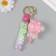 A keychain plastic with a carbine, a strap "Lollipop with a bow" Water with a glitter of 4x4x6.5 cm