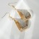 Earrings with rhinestones "wave" arc, white color in gold