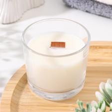 A candle made of soy wax in a glass with a wooden wick 