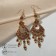 Hanging earrings with rhinestones "East" fan, red color in black gold, 9cm