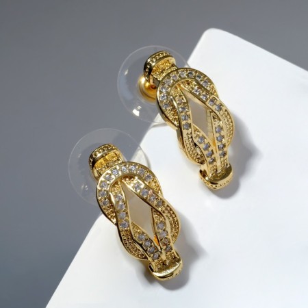 Earrings with rhinestones "knot", white color in gold