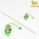 A teaser-pile with a shiny mouse on a wooden handle, green